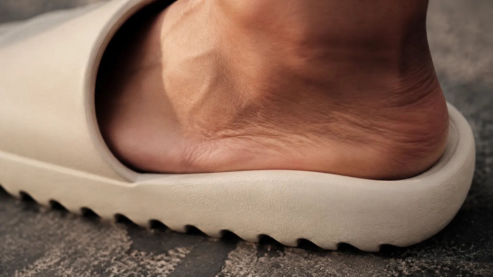 Runner slipping into recovery sandals immediately after finishing a road run